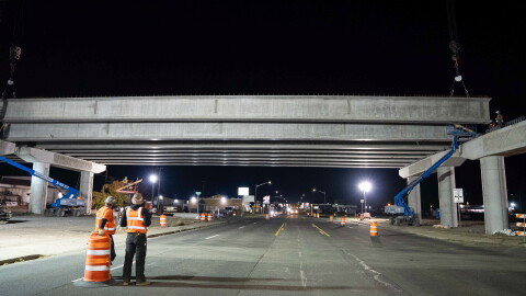 Crews watch the placement of concrete girders for the North South Corridor over Sprague Avenue.