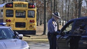A Kentucky State Police trooper checks with a motorist entering Marshall County High School Wednesday, Jan. 24, 2018, near Benton, Ky. Two students died and another 18 people were injured in a shooting the day before. 