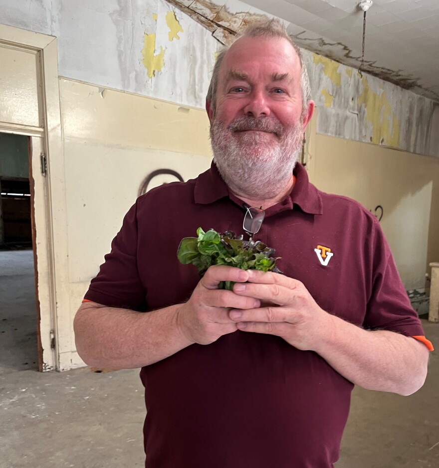 Steve Critchfield, one of the funders for MOVA technologies and Vegg Inc., stands holding spring mix that was harvested after growing inside a former school building. The lettuce was grown using MOVA's carbon filtration system. Vegg Inc. is redeveloping the former school building and was loaned money to purchase the building for $1 million.