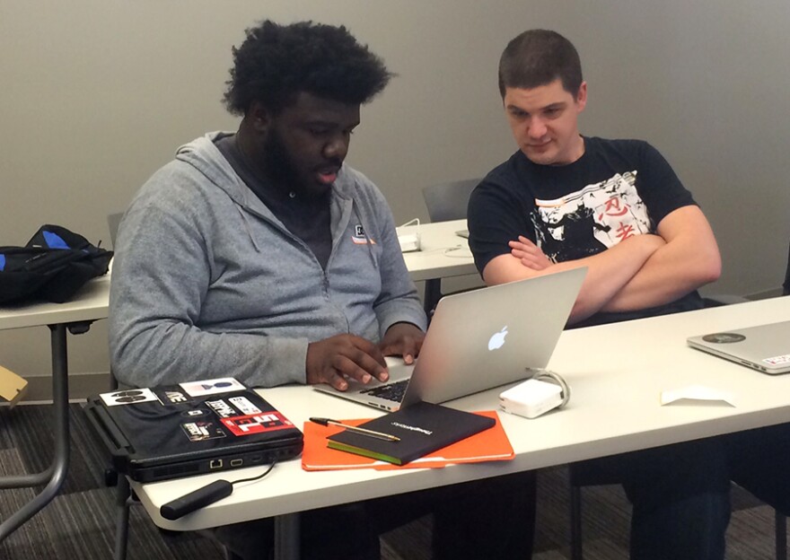 Marcus Mucherson (left) uses HTML to build the beginnings of a website as local web developer Bryan Maynard looks on, ready to help if needed.