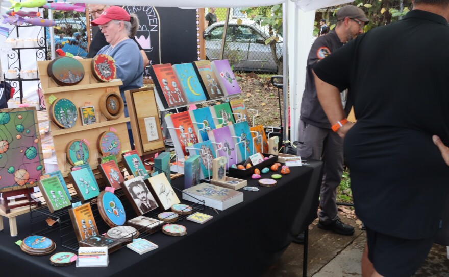 A vendor's art on display in a market booth.