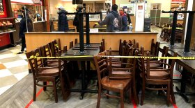The seating area is closed-off due to coronavirus restrictions at a food court, as customers line up for take-out food in a grocery store in Arlington Heights, Ill., on Friday, Nov. 13, 2020.