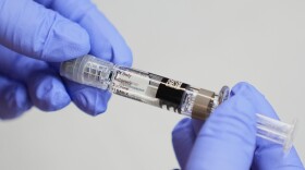 FILE - A certified medical assistant holds a syringe for a flu vaccine at a clinic in Seattle, on Wednesday, Sept. 10, 2025. (AP Photo/Lindsey Wasson, File)