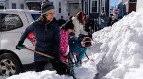 Boston Mayor Michelle Wu, left, lends a hand shoveling snow from around a fire hydrant, Tuesday, Feb. 24, 2026, in South Boston. (AP Photo/Sophie Park)