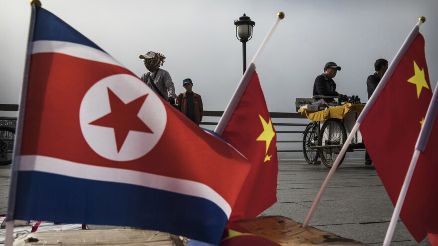 A China-based tour company says it will no longer take U.S. citizens to North Korea. Here, Chinese vendors sell flags of North Korea and China along the Yalu River in Dandong, northern China, along the border with North Korea.