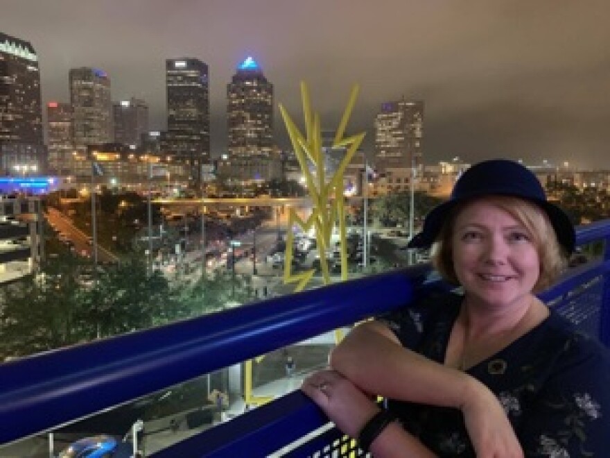 Teacher Tracy Flanagan stands by a cityscaoe 