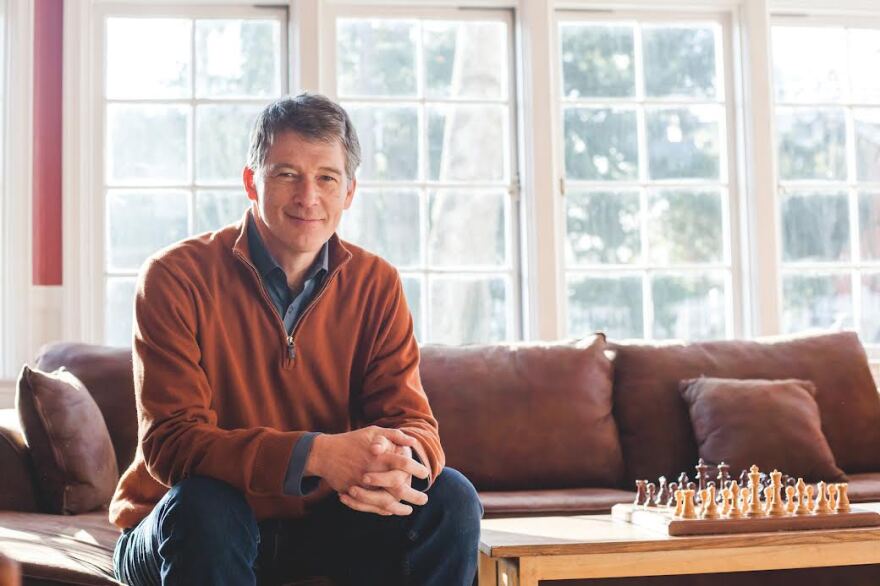 Man sitting on couch looking into camera.