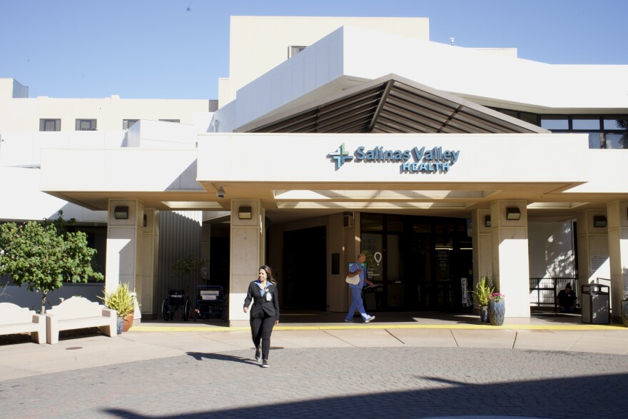 A person walks out of a hospital building.