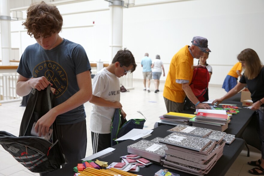 Volunteers stuff some of the more than 300 backpacks to be distributed Monday at Ellsworth Avenue School.