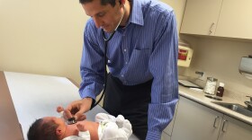 Dr. Eric Ball examines a healthy 5-day-old patient in his office in Ladera Ranch, Calif. Ball and colleagues decided this week to take only patients whose parents follow the recommended vaccine schedule.