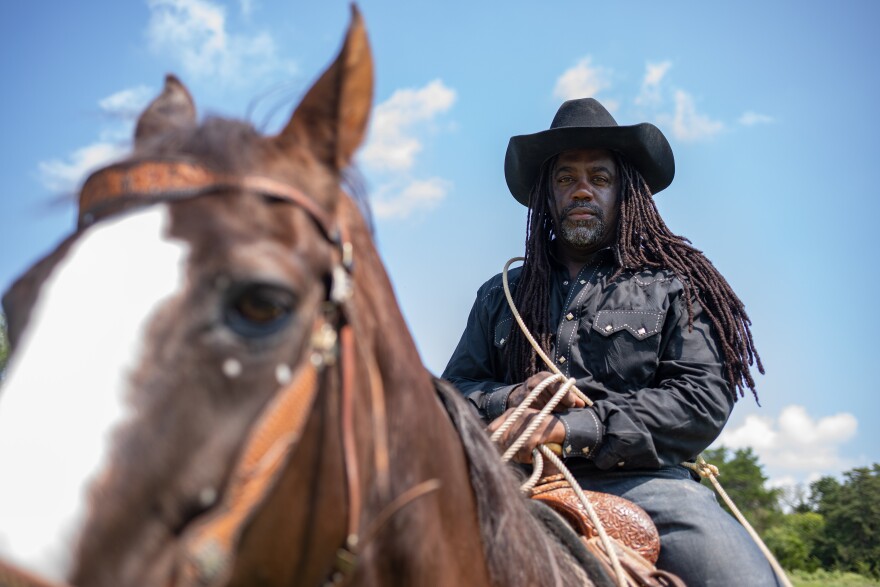 Ke' Elronn Hatley astride a horse with his lasso in the ready position.