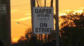 A Princeton bus driver holds an "On Strike" sign outside of First Student's bus garage in Sharonville.