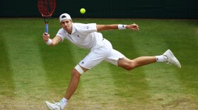 John Isner of the United States returns against Kevin Anderson of South Africa during their men's singles semifinal match on day 11 of the Wimbledon Lawn Tennis Championships at All England Lawn Tennis and Croquet Club on July 13, 2018 in London. (Clive Brunskill/Getty Images)