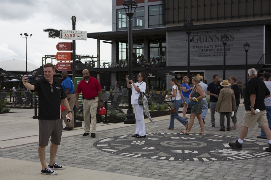 Visitors walk in front of a sign indicating other Guinness breweries around the world, including the flagship one in Dublin.