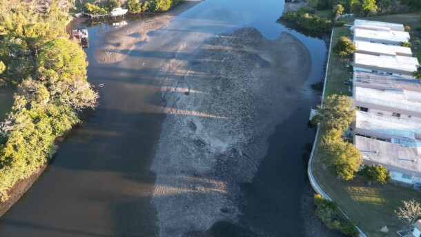 A blob of sand protrudes from the center of Phillippi Creek, as shown in an aerial image