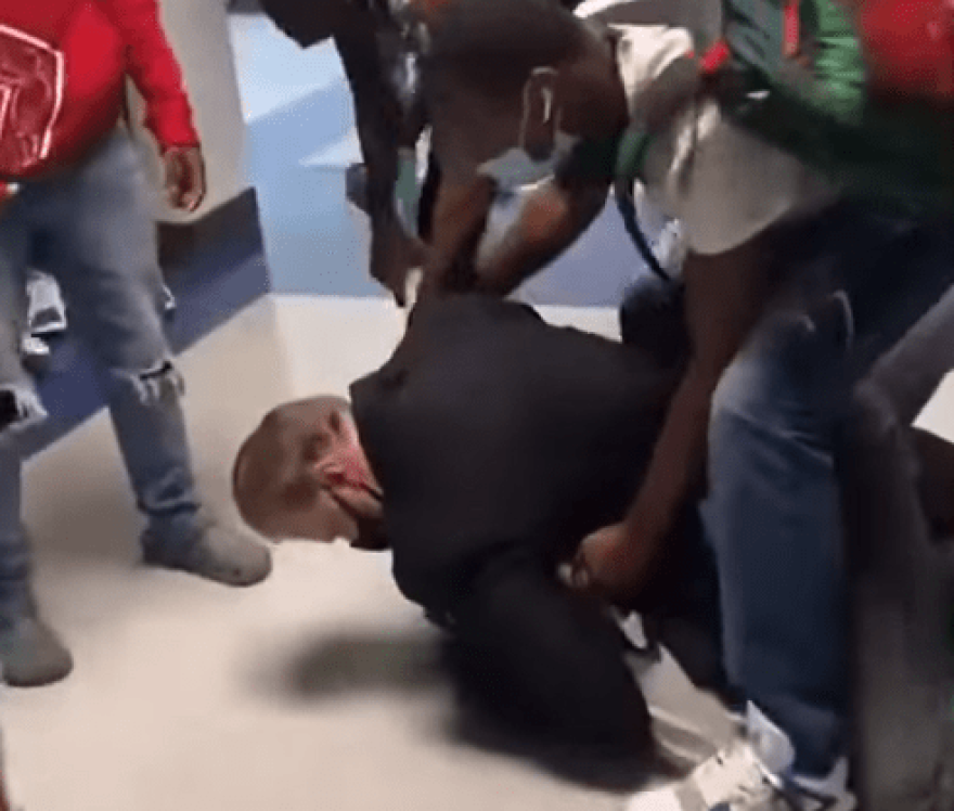 Moore High School teacher William Bennett pinning a student to the ground in a fight.