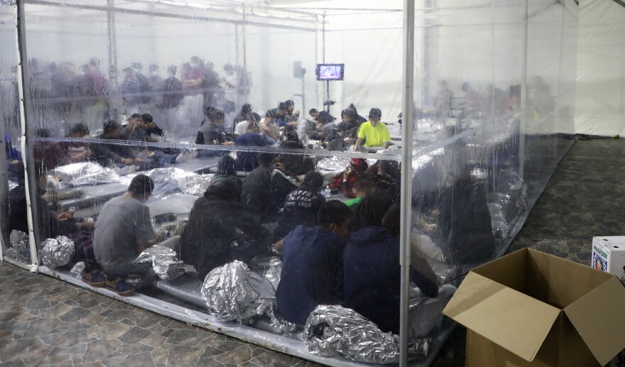 Detained families and unaccompanied children sit in areas divided by plastic sheathing at a temporary processing facility in Donna, Texas.