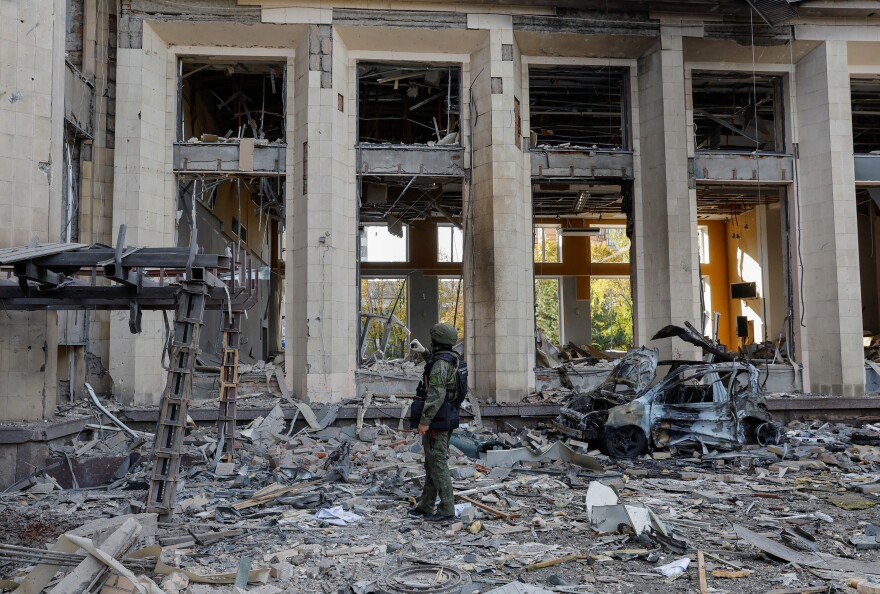 Residents walk past an apartment building on Wednesday in Mariupol, Ukraine, destroyed during the war with Russia.