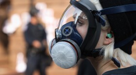 A protester wears a gas mask during a standoff with Rochester police outside City Hall on Sept. 16.