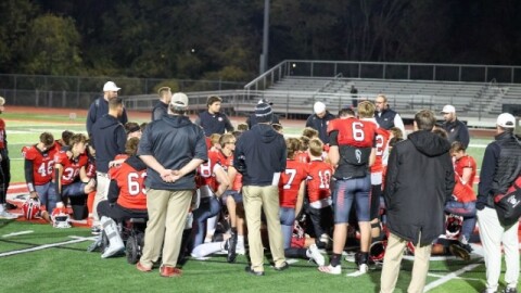 Ozark football huddles up after game last season