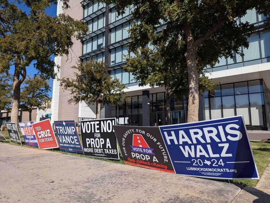 Political signs lined up outside of the vote center at Citizens Tower in downtown Lubbock amid early voting on October 31, 2024.