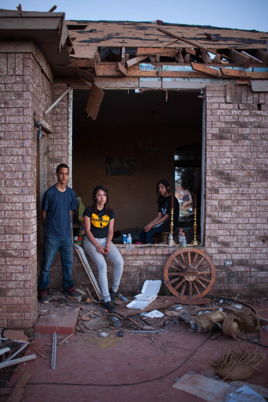 Siblings (from left) Alan, Sylvia and Ariel Trillo pose at their home in the Heather Wood subdivision in Moore. The Trillo home is one of the few homes there that is still standing, though everything inside is damaged.