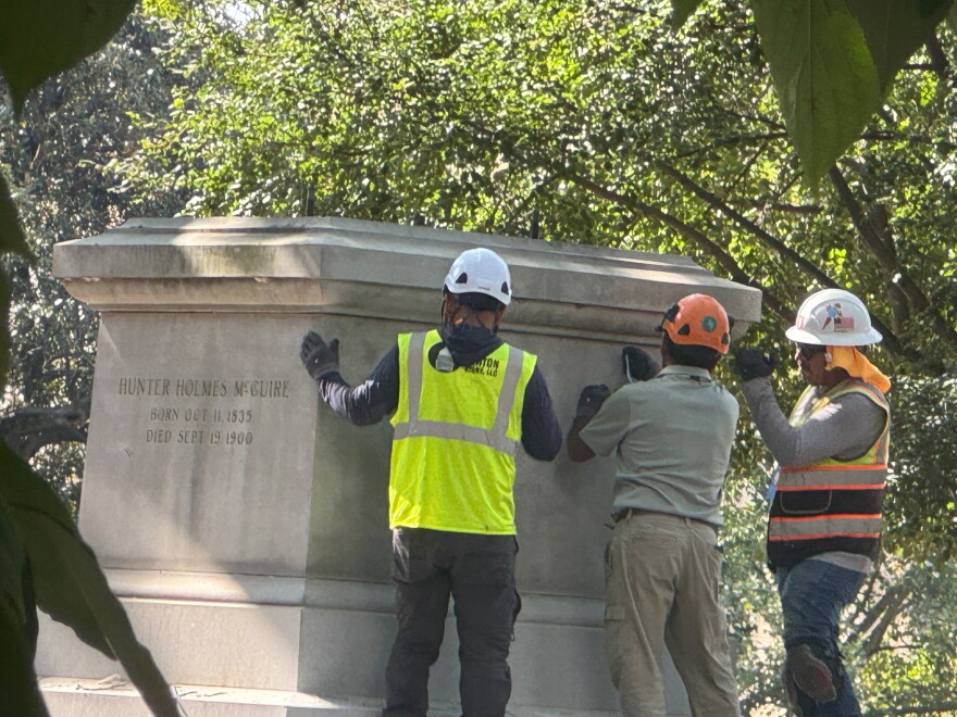 Workers examine the base of the monument to Confederate surgeon Hunter McGuire on August 28, 2026.