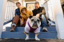 Elle Brodsky, left, Troika Brodsky, right, their son Daniel, 6, and their foster dog, a 3-year-old English Bulldog named Bella sit outside their Maplewood home on Tuesday, Jan. 20, 2026. The Brodsky’s home is intersected by the St. Louis County and city divide.
