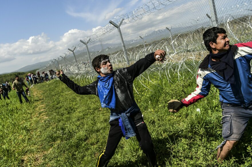 Refugees and migrants clash with Macedonian soldiers as they storm the border fence near Idomeni on Sunday.