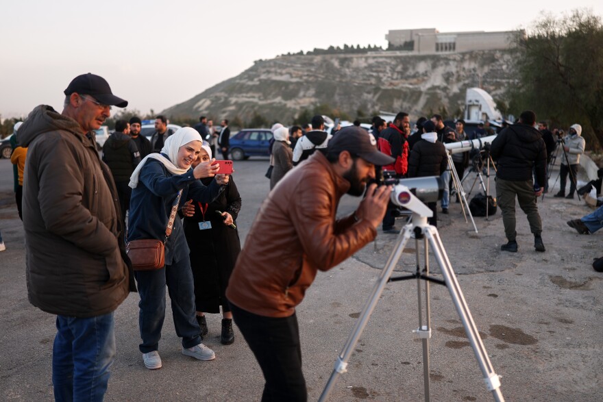 People gather to sight the Ramadan crescent moon marking the beginning of the holy month of Ramadan at the foothills of Mount Qasioun near the Tomb of the Unknown Soldier in Damascus, Tuesday, Feb. 17, 2026.