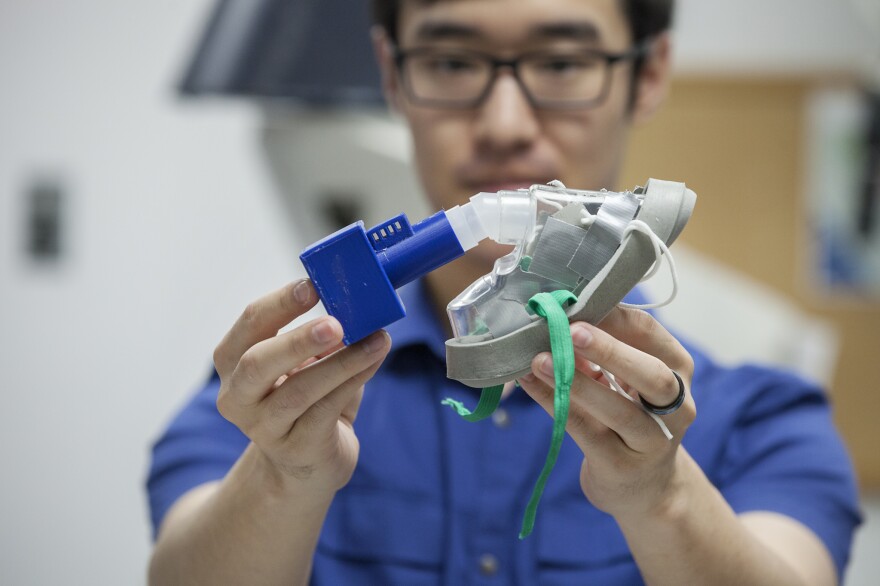 Joshua Kim shows how the filter cartridge can be adapted to fit onto existing masks.