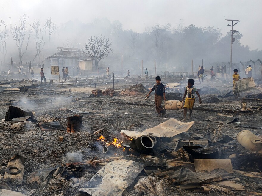 Rohingya refugee boys salvage a gas cylinder after a major fire in the Balukhali camp in Bangladesh.