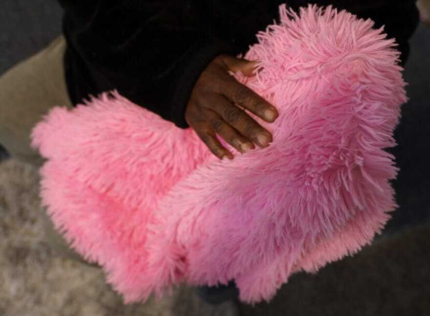 Carolou holds her daughter’s fuzzy pillow case. She’s kept it in her room since her daughter fled to Canada. April 30, 2025.