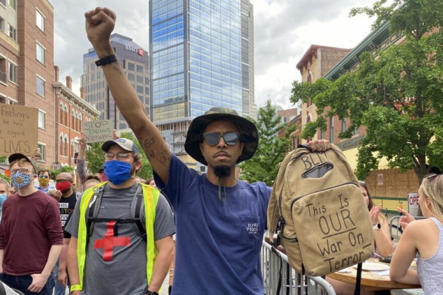 Cory Wise marches with protesters along Massachusetts Avenue on Wednesday, June 10. His bag says “this is our war on terror.