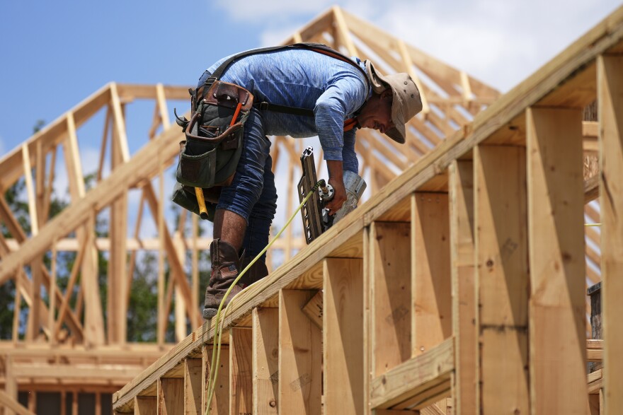 A worker works on the roofing structure of new home under construction, Tuesday, July 15, 2025, in Richardson, Texas. (AP Photo/Tony Gutierrez)