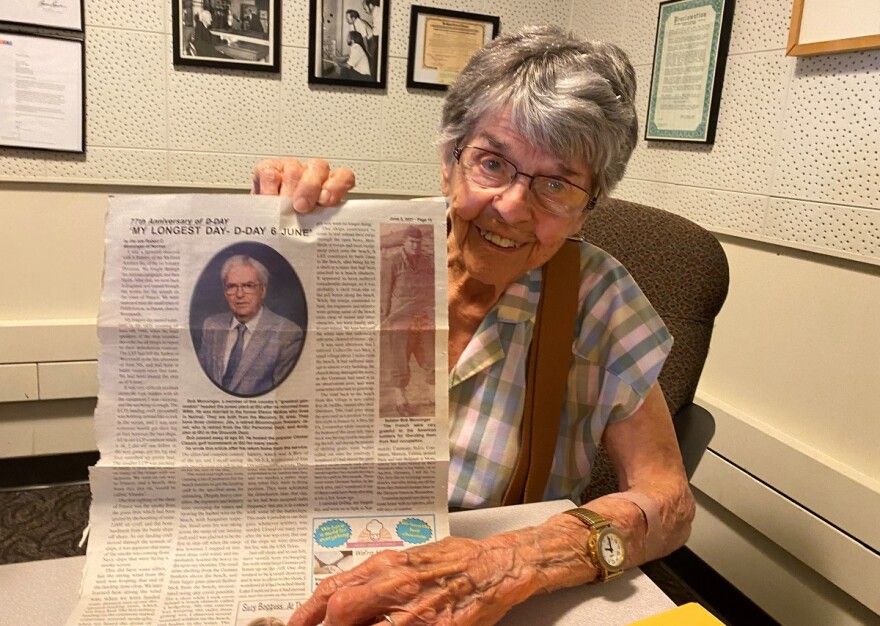  Eleanor Monninger holds up a Normalite newspaper article in which her now late husband wrote about his experience serving during the D-Day invasion. 