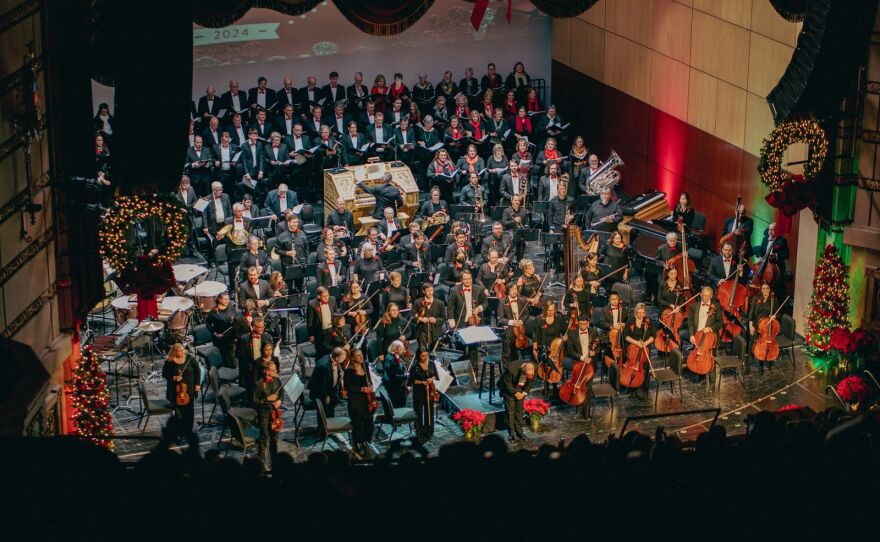 An ensemble of musicians holding instruments. 