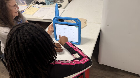 PEAK Literacy tutor Mary Ellen Delaplaine works with Kristina Keith on a reading activity at Sweetwater Square in Gainesville, Fla., on Sept. 16, 2026. Students use tablets and other learning materials during tutoring sessions.
