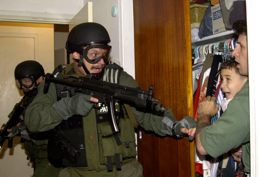 On April 22, 2000, government officials seized Elian Gonzalez, who is seen being held in a closet by Donato Dalrymple (right), one of the two men who rescued the Cuban boy from the ocean after his mother died trying to come to the U.S. Elian's U.S.-based relatives fought to keep him here, but the U.S. finally returned him to Cuba, where his father lived.