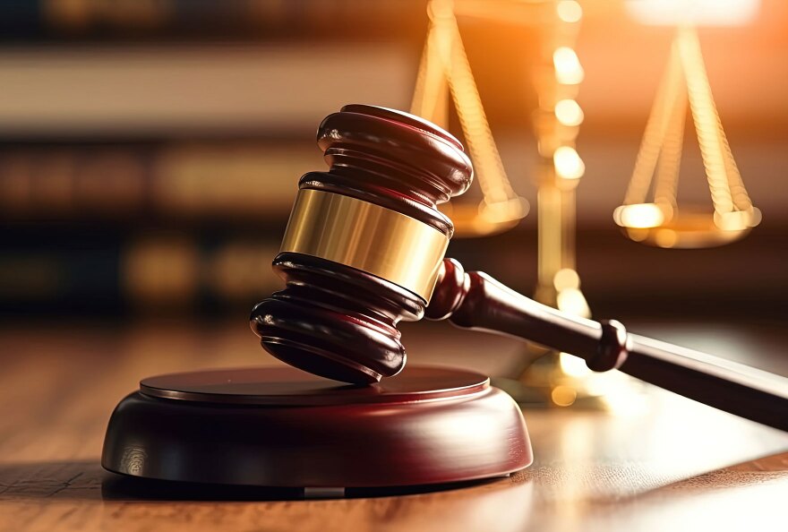 Courtroom gavel with scales of justice in the background.