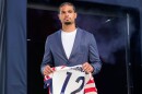man carries a soccer jersey with his name and number.
