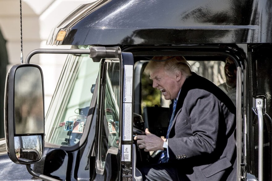 President Donald Trump pretends to drive as he gets in an 18-wheeler as he meets with truckers and CEOs regarding healthcare on the South Lawn of the White House. (Andrew Harnik/AP)