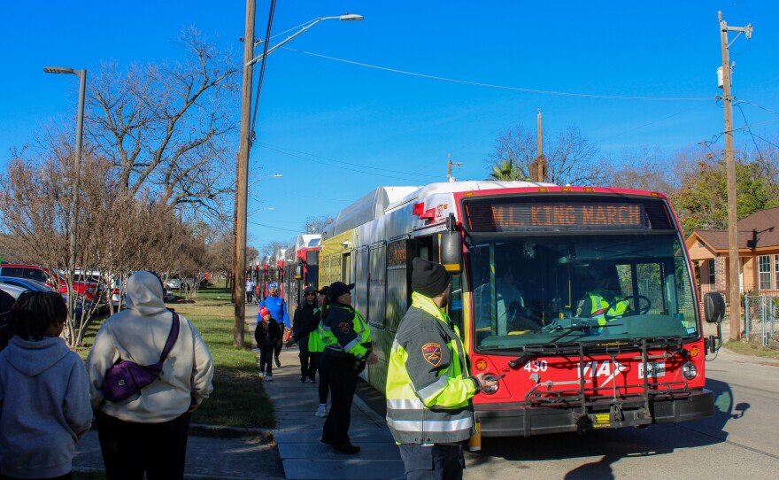 A line of VIA buses line up to transport marchers.
