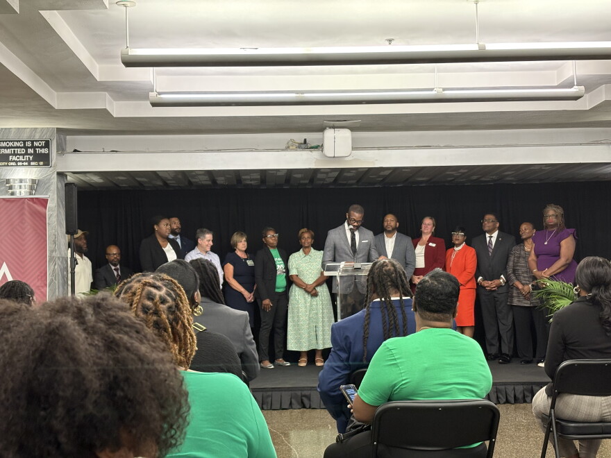 A crowd sits facing Birmingham Mayor Randall Woodfin and other city leaders at a press conference unveiling the city's 5-year strategic plan to reduce violence.
