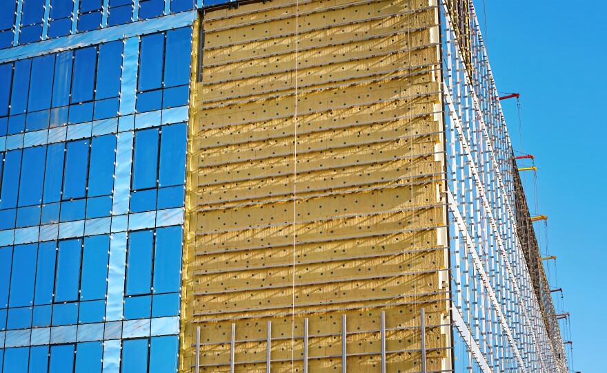 Mineral wool insulation of building facade, thermal insulation of externall wall with wool. Glass wall installation. Installing glazed ventilated facade, building renovation and heat improvement