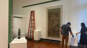 Installation Coordinator Timothy Dygert, on the left, uses the 3D model display of a bronze vessel next to Cofrin Curator of Asian Art Tongyun Yin. (Tomas Curcio/WUFT News)