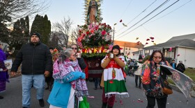 Marianna Galeno throws rose petals before the Virgin Mary statue during the procession. The statue will live with her for the year.