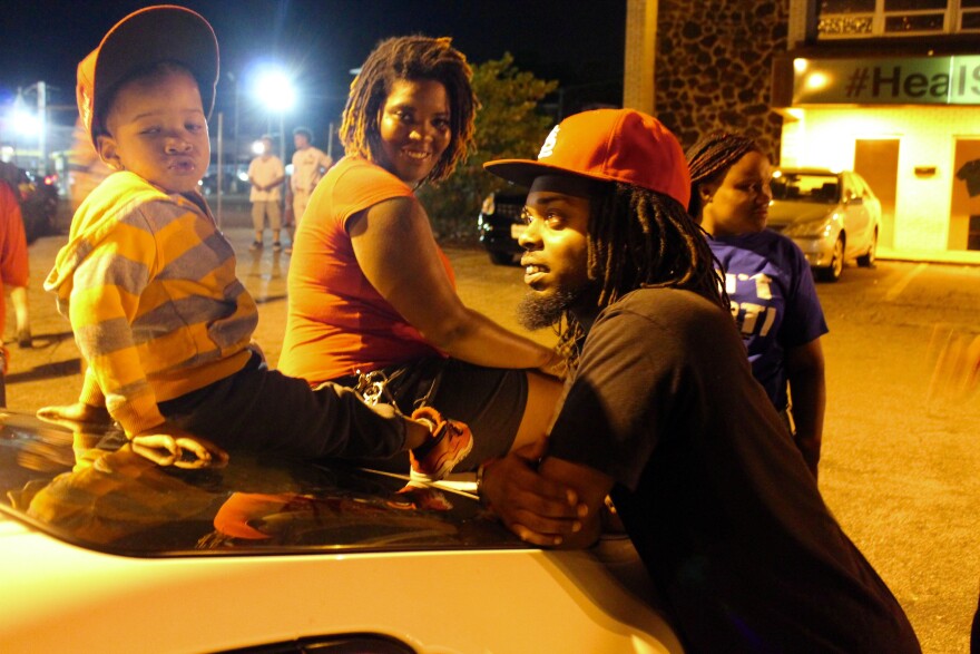 Darnell Wilkes and his son Khalliel wait around at Tuesday's protests along West Florissant Avenue in Ferguson.