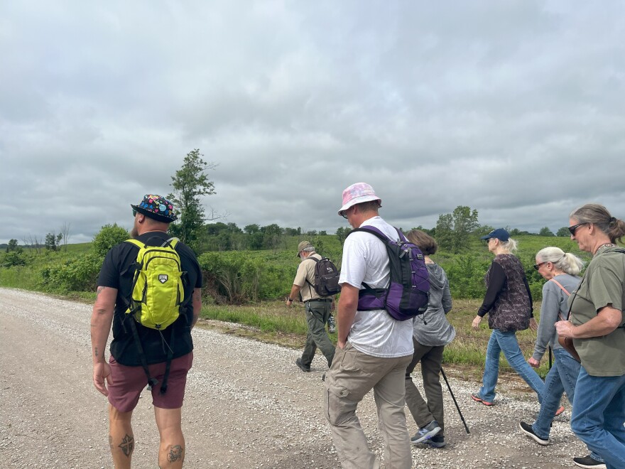 Prairie State Park naturalist Dana Hoisington leads a group of visitors on the June 7 bison saunter.