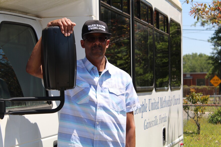 The Rev. Milford Griner stands next to a bus belonging to his home church, Bartley Temple United Methodist Church. “Retiring from ministry after all these years, that’s only one part of my life,” he said. “An important part, it’s the biggest part because I’ve spent over half of my life in ministry.” (Lillian Lawson/WUFT News)